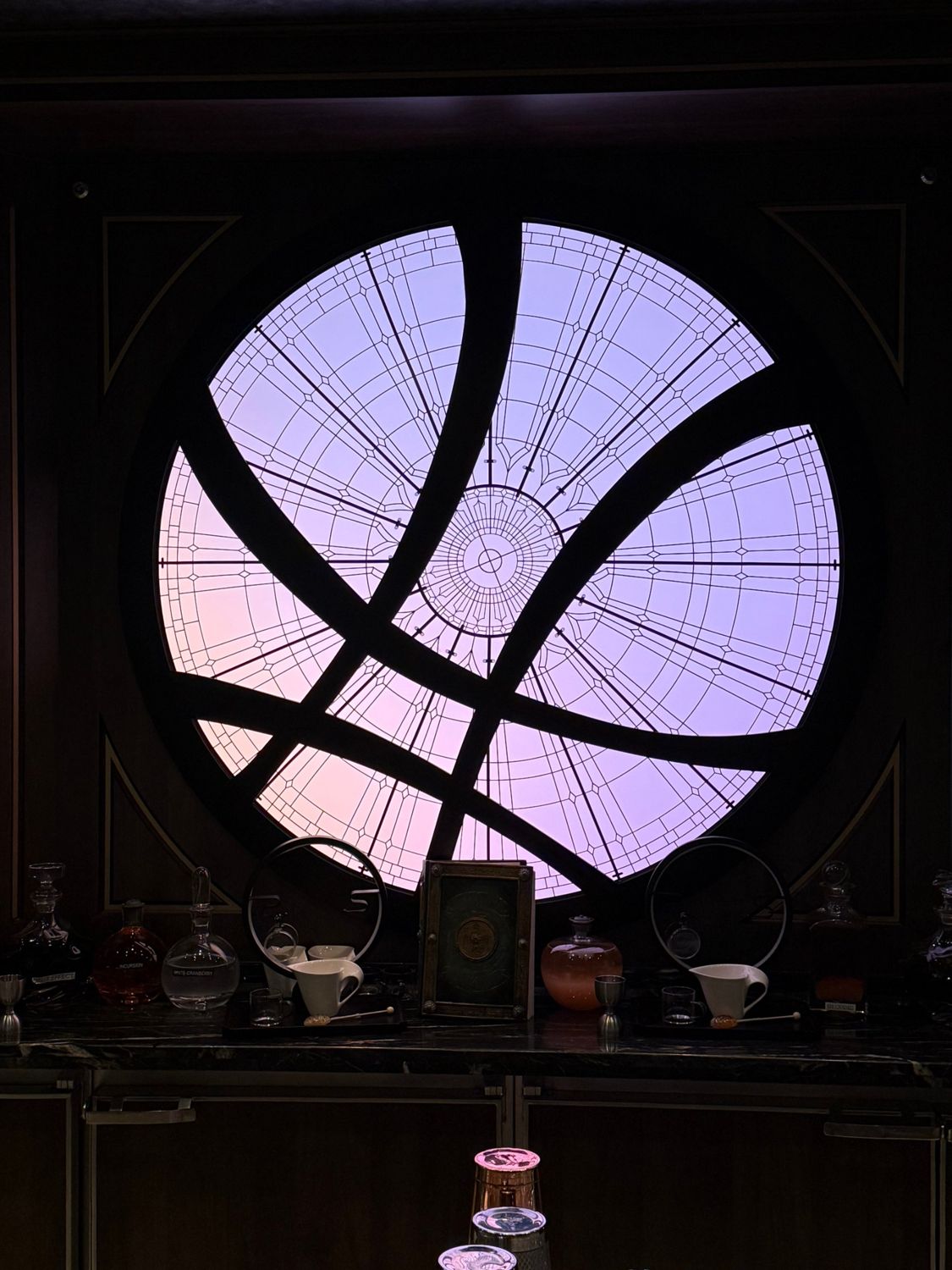 A backlit Doctor Strange window of the worlds above the bar on the Disney Destiny