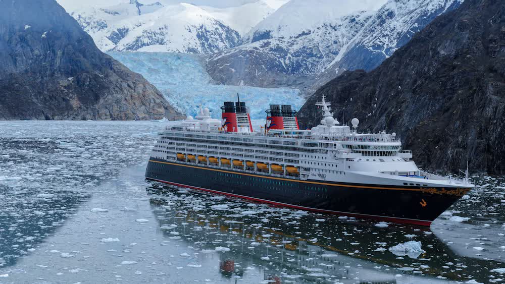 The Disney Wonder amid icebergs in a glacier-lined Alaskan fjord