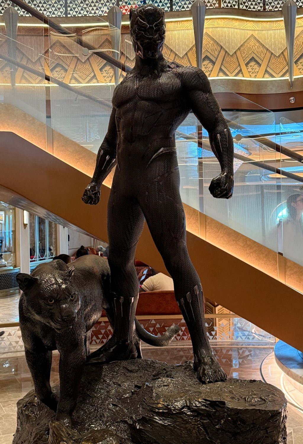 The Black Panther statue standing on a rocky base with a panther beside it near a grand staircase