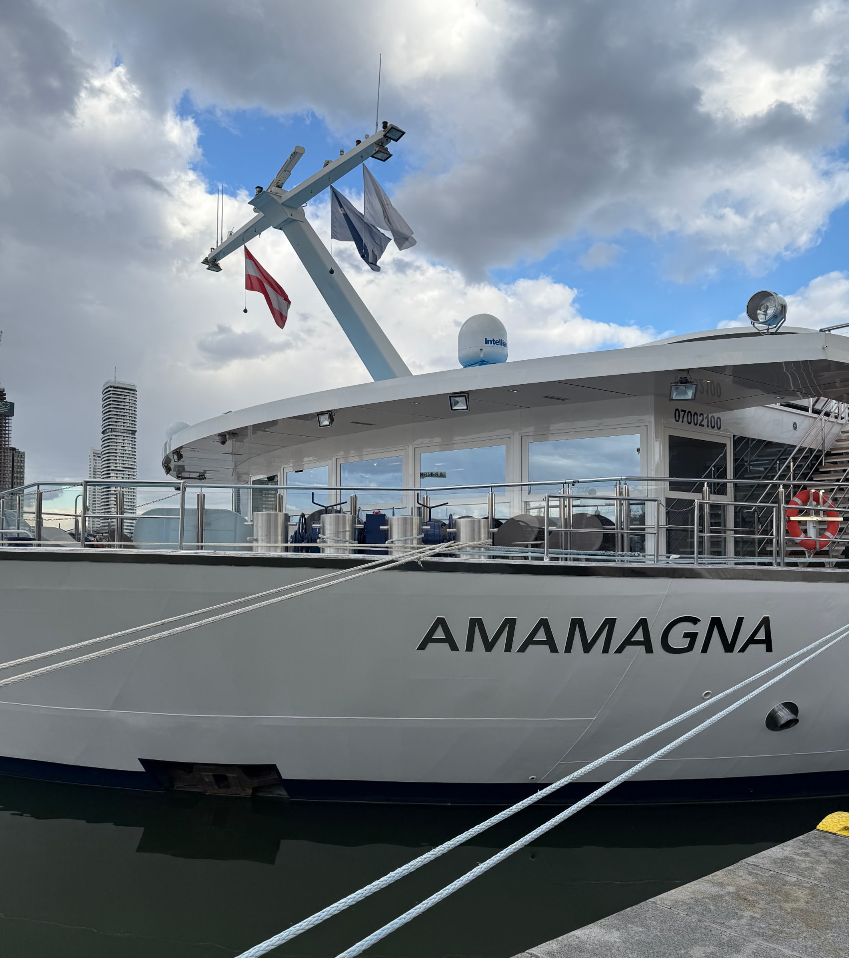 AmaMagna river ship at dock beneath a bright, cloud-filled sky