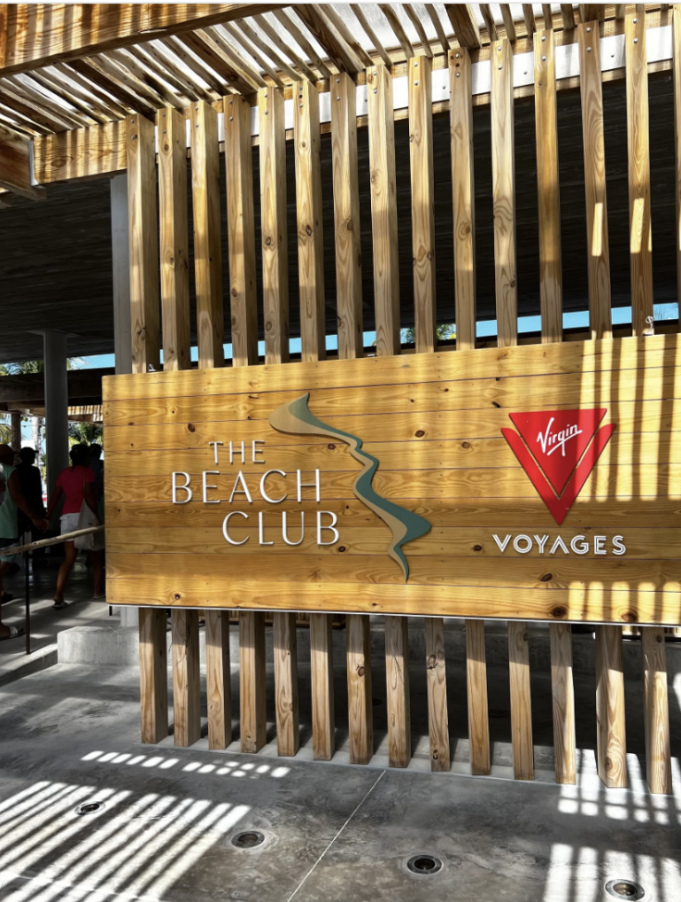 The Beach Club sign at Bimini beneath a slatted wooden canopy