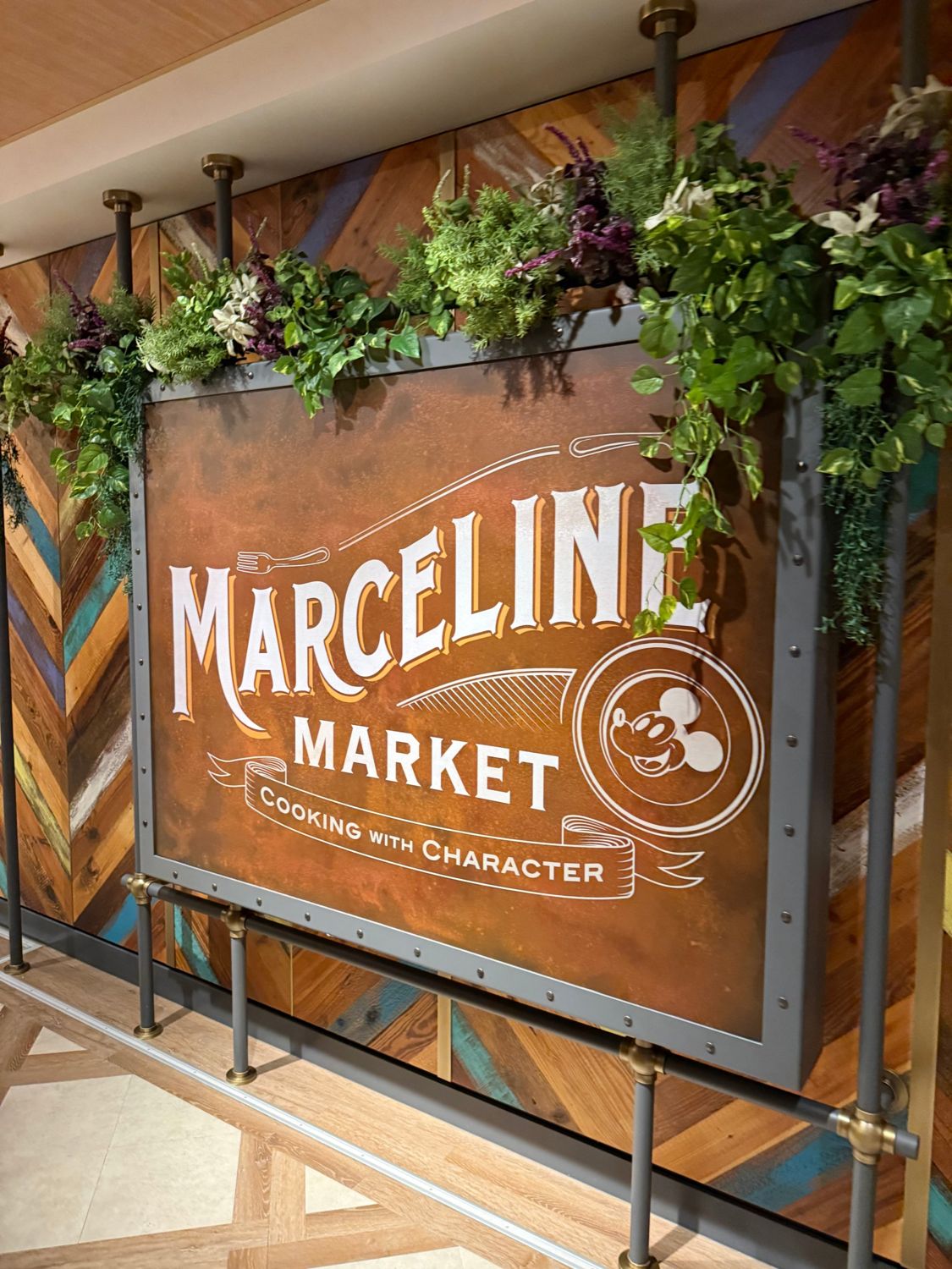 The Marceline Market sign framed on a chevron wood-paneled wall
