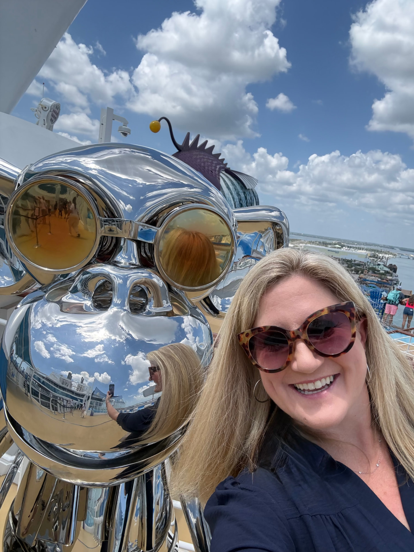 Travel advisor Bridget Edwards of Illumia Travel beside the chrome anglerfish sculpture on the pool deck of Utopia of the Seas