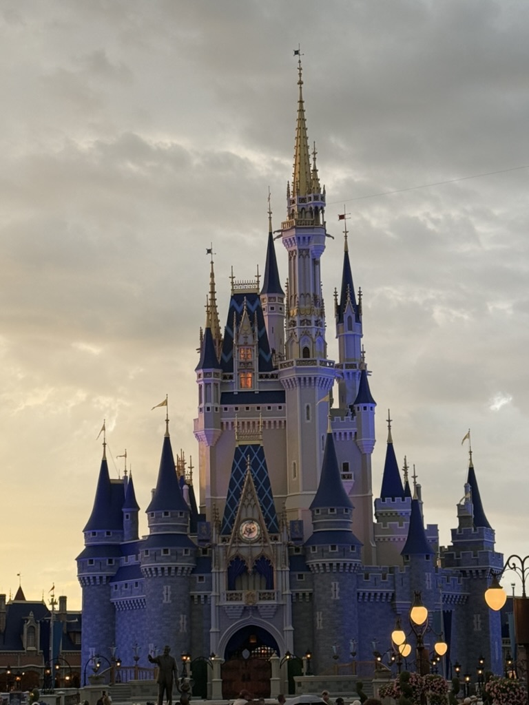 Cinderella Castle glowing at dusk against a golden and navy sky