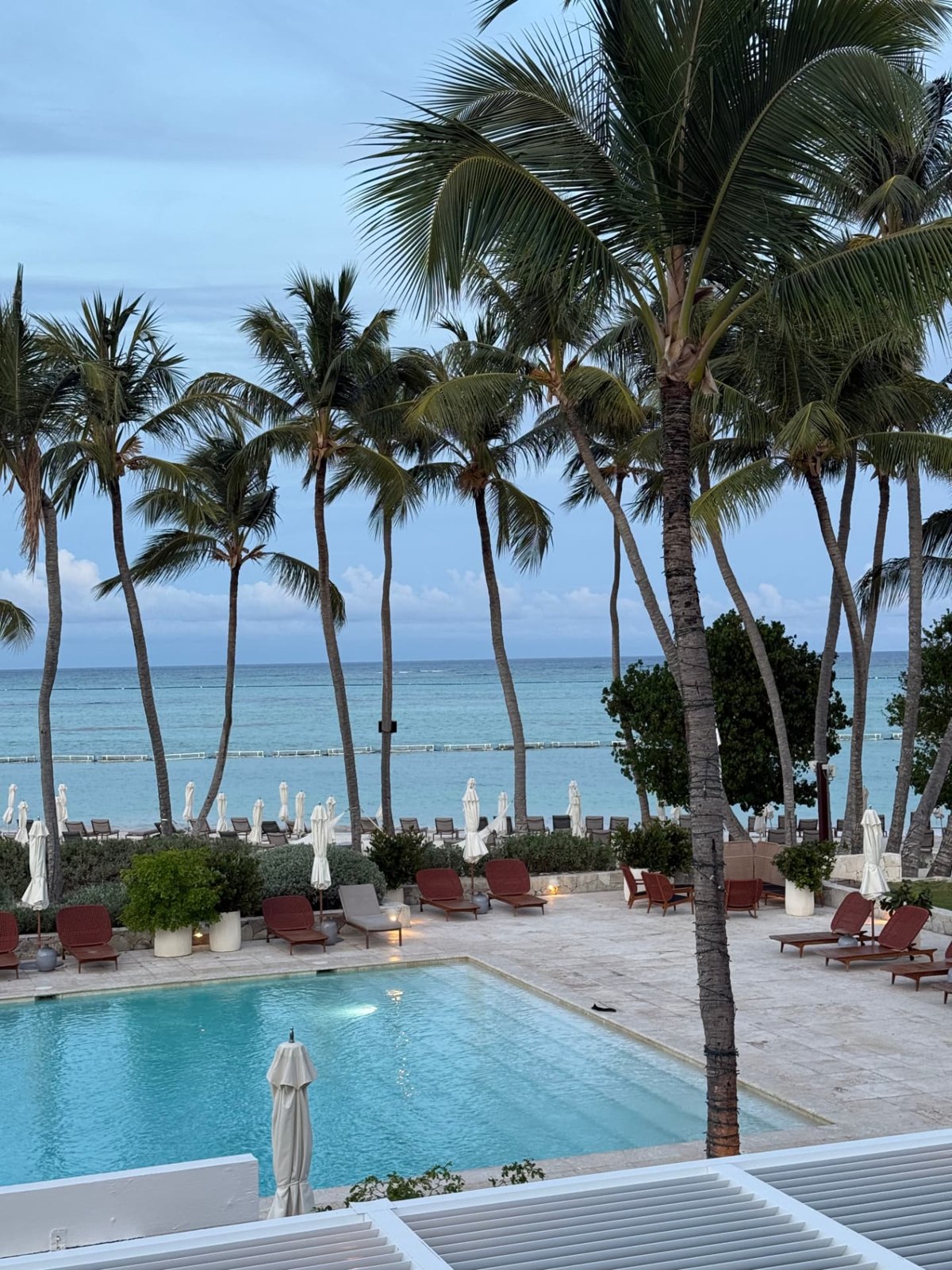 Palm-lined pool and beachfront loungers at Casa de Campo Resort and Villas
