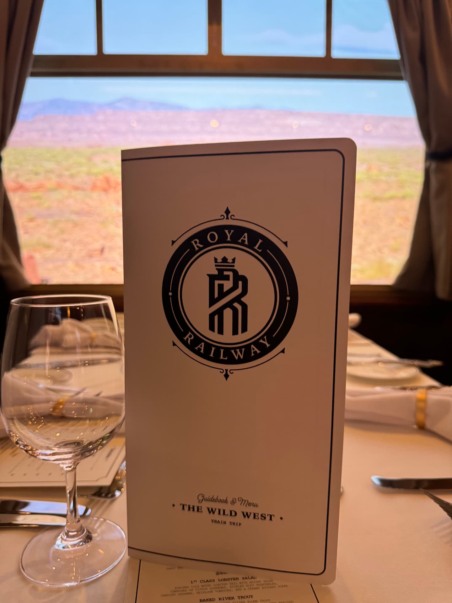 A Royal Railway menu standing upright on a set dinner table