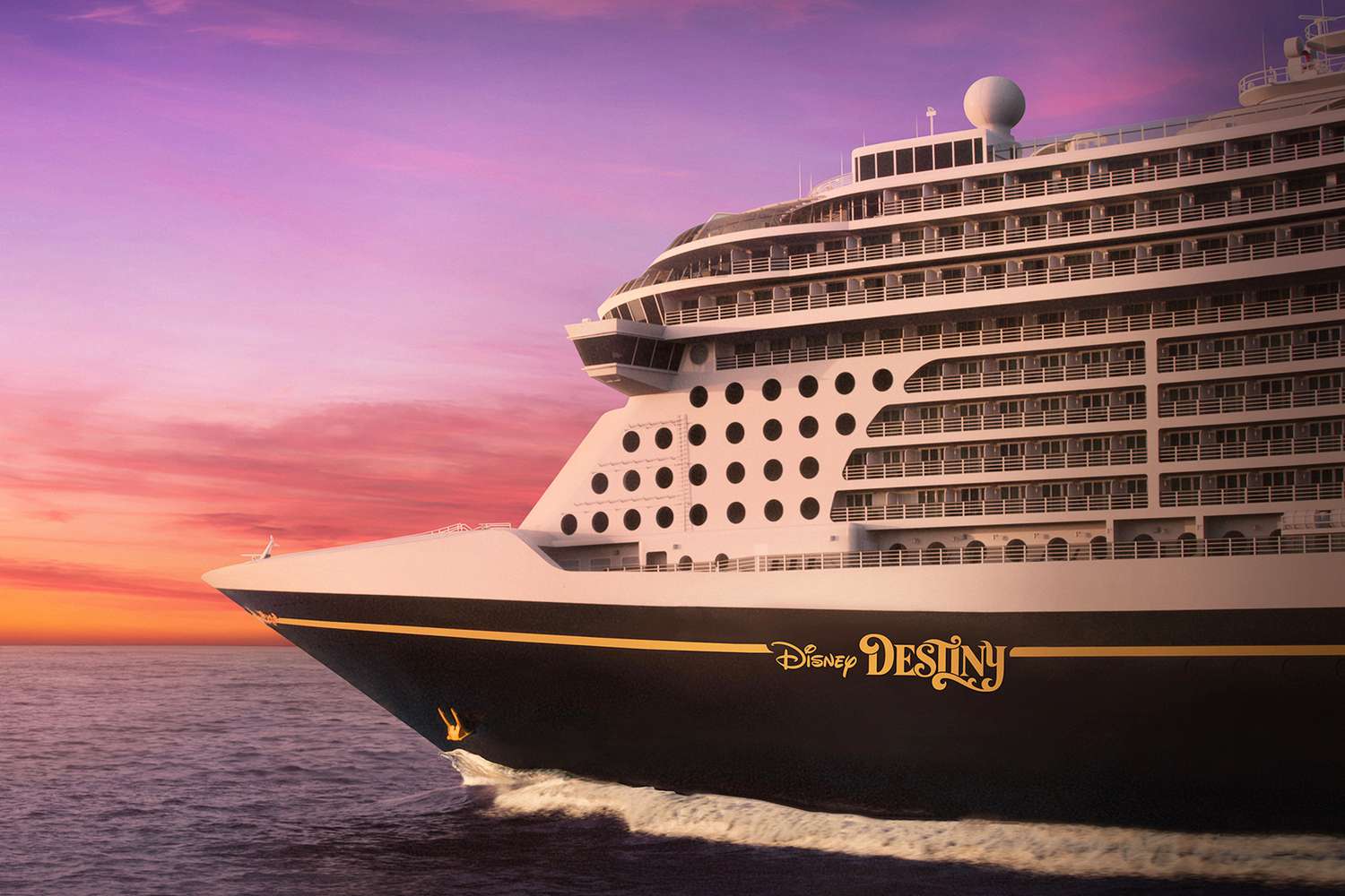The bow of the Disney Destiny against a sunset sky