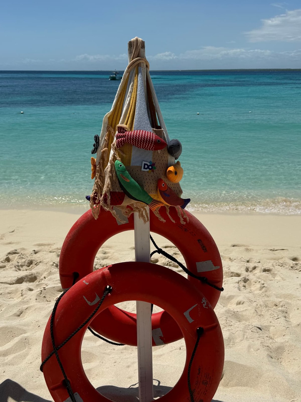 Lifebuoys and colorful beach decorations beside turquoise water at Casa de Campo